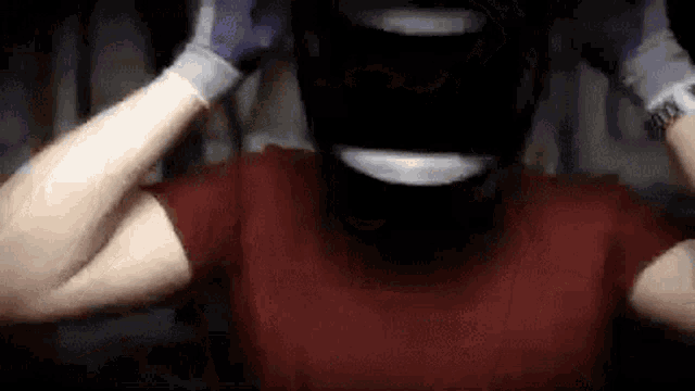 a man wearing a helmet and gloves is making a face .