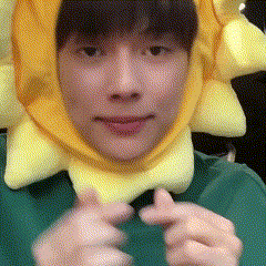a young man wearing a yellow sun hat is making a funny face .