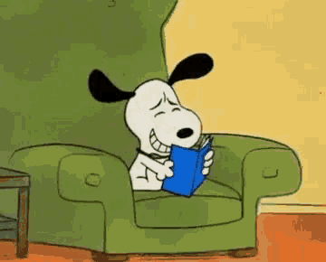 snoopy is reading a book while sitting in a green chair .
