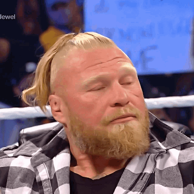a man with a beard is sitting in front of a sign that says ' jewel ' on it