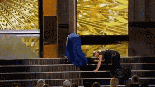 a woman climbs a set of stairs while a crowd watches