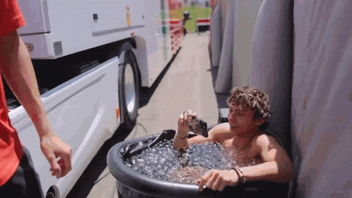 a man is taking a picture of himself in a tub of water .