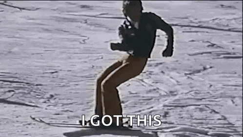 a man is riding a snowboard down a snow covered slope .