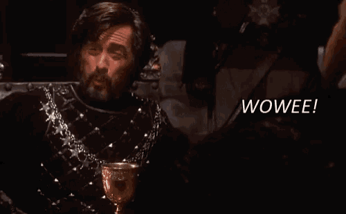 a man with a beard is sitting in a chair with the word wowee in the corner