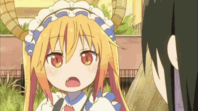 a girl with horns is standing next to another girl in a maid outfit .