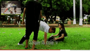 a man is doing a handstand while a woman sits on the grass with the words saque la cola v on the bottom