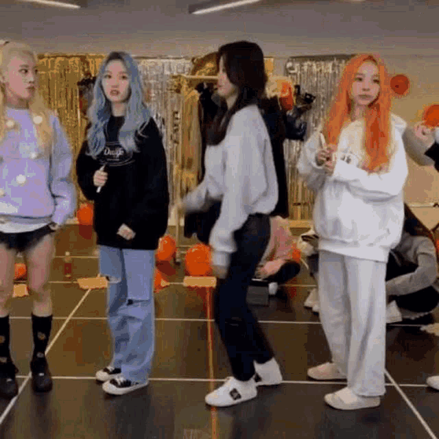a group of girls are standing next to each other on a dance floor in a room .