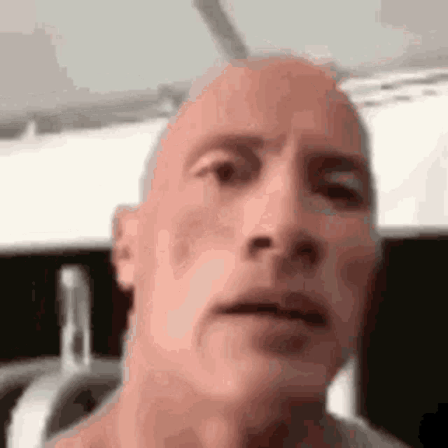 a close up of a man 's face with a bald head .