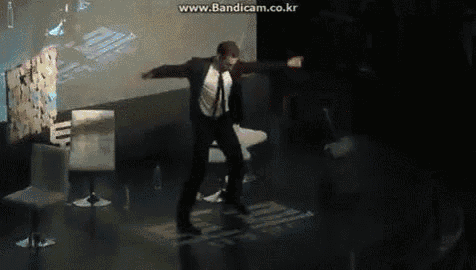 a man in a suit and tie is dancing on a stage with the website www.bandicam.co.kr in the corner