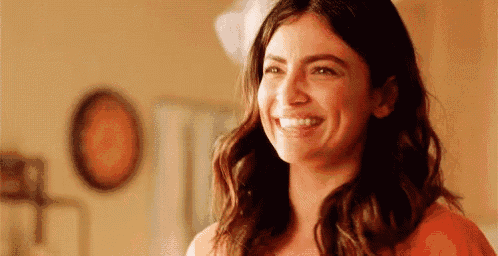 a woman is smiling and looking at the camera .