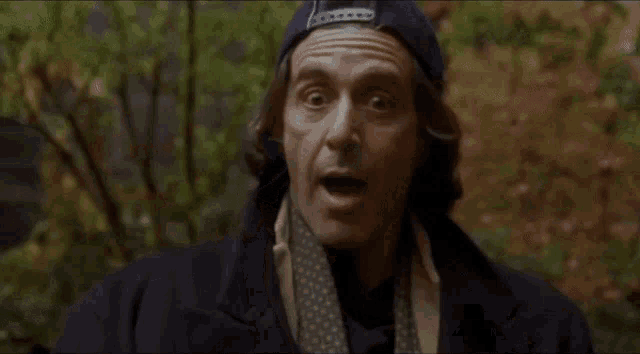 a man with a surprised look on his face is wearing a hat and scarf and says ha