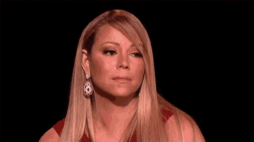 a woman in a red dress and earrings is making a funny face .