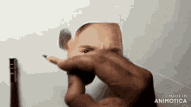 a person is holding a pencil in front of a drawing of a face .