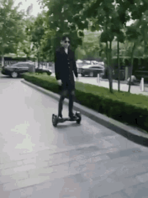 a man is riding a hover board on a sidewalk .