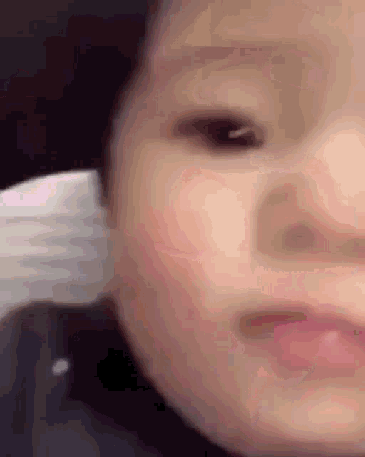 a close up of a baby 's face with a blurry eye