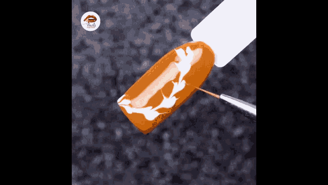 a close up of a nail with a brush and a bottle of nail polish