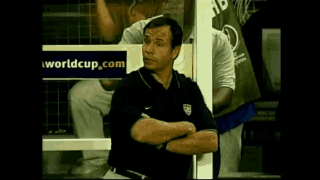a man sitting in front of a worldcup.com sign
