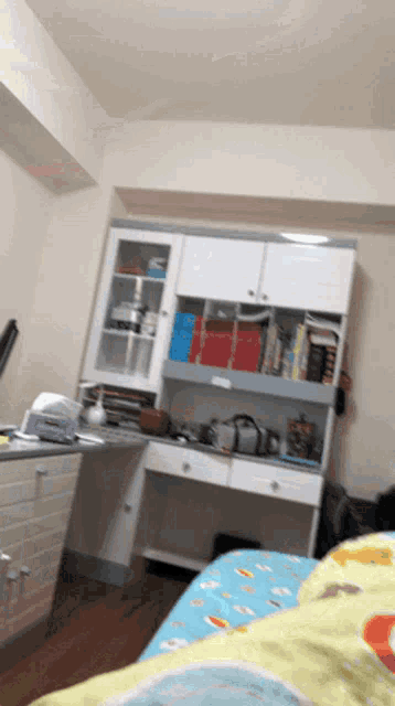 a bedroom with a bed a desk and a shelf