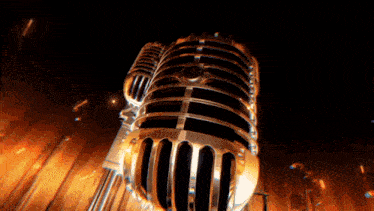 a close up of a gold microphone with flames behind it
