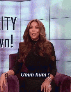 a woman in a black dress is sitting in a chair with the words umm hum behind her