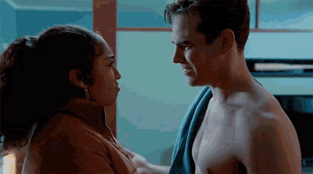 a man and a woman are looking at each other and the man has a towel around his neck