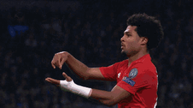 a soccer player wearing a red shirt that says ' uefa champions league ' on it