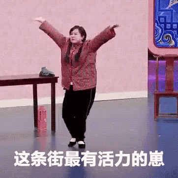 a woman in a red jacket is dancing on a stage with her arms outstretched in chinese