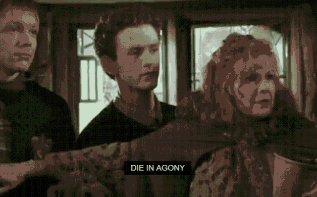 a group of people standing next to each other with a sign that says die in agony on it