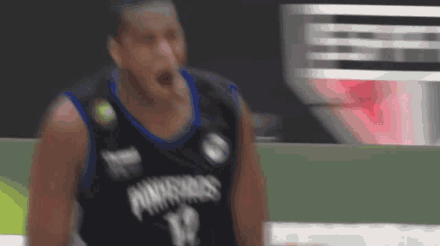 a basketball player wearing a black and blue jersey with the number 12 on it