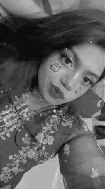 a woman is taking a selfie with a hello kitty face mask on her face .