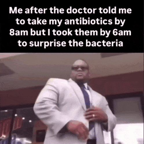 a man in a suit and tie is standing in front of a building with the words me after the doctor told me to take my antibiotics