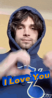a man wearing a blue hoodie is making a heart shape with his hands while saying i love you .