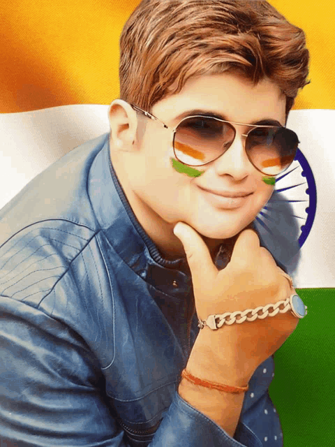 a young man wearing sunglasses and a bracelet is smiling with a flag painted on his face