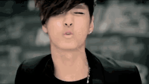 a close up of a young man making a funny face with his eyes closed .