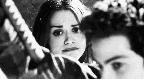 a black and white photo of a man and a woman . the woman is crying and the man is looking at her .