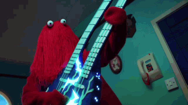 a red monster is playing a guitar with a lightning bolt on the strings