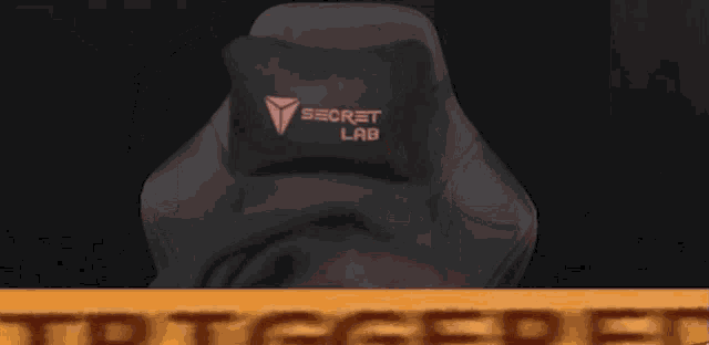 a man wearing headphones is sitting in front of a yellow sign that says trigger