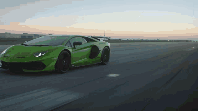 a green sports car is driving down the road