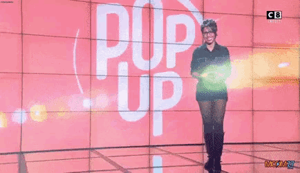 a woman is dancing on a stage in front of a screen that says pop up