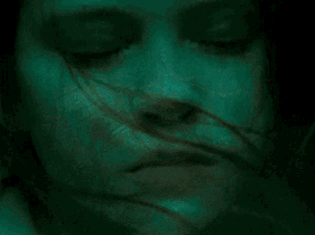 a close up of a woman 's face with a blue light behind her