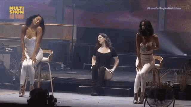 three women are dancing on a stage with the words multi show at the top