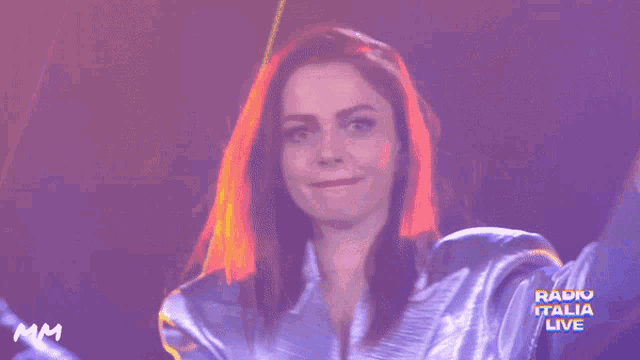 a woman is smiling in front of a radio italia logo