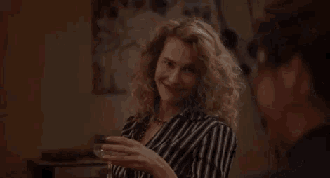 a woman in a striped shirt is talking in a foreign language .