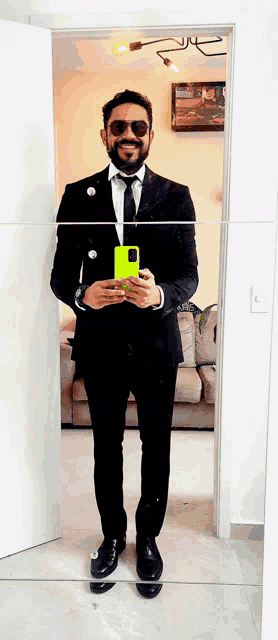 a man in a suit takes a picture of himself in a mirror