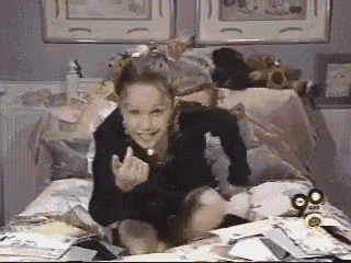 a little girl is sitting on a bed with a 90 degree angle