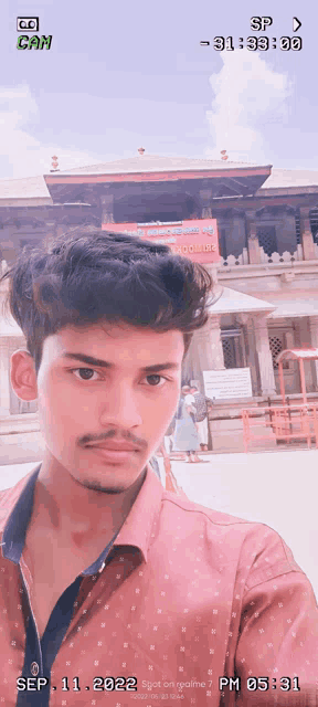 a young man is taking a selfie in front of a building with the date sep 11 2022