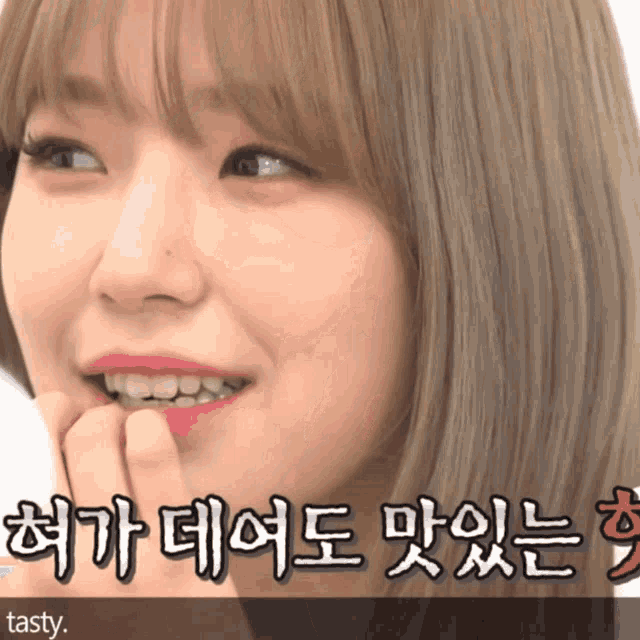 a close up of a woman 's face with tasty written on the bottom right