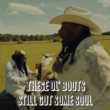 a man in a cowboy hat is playing a piano in a field with the words " these ol boots still got some soul " below him
