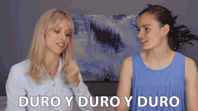 two women standing next to each other with duro y duro y duro written on the screen