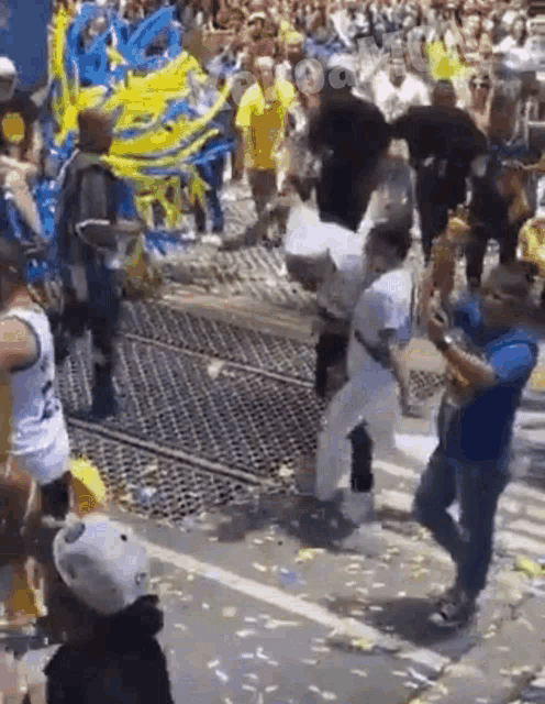 a group of people are dancing on a street while a man holds a saxophone .